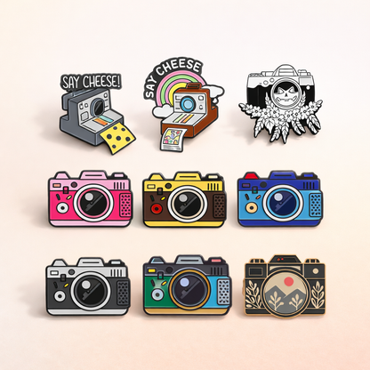 Set of colorful camera-themed pins on a beige background