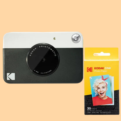 Kodak Printomatic camera with Kodak photo paper packaging on a white background