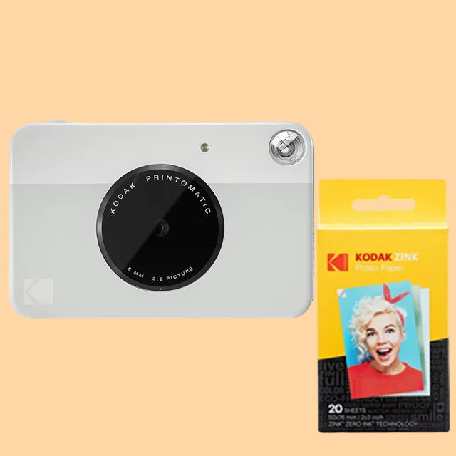 Kodak Printomatic camera with a pack of Kodak photo papers on a white background