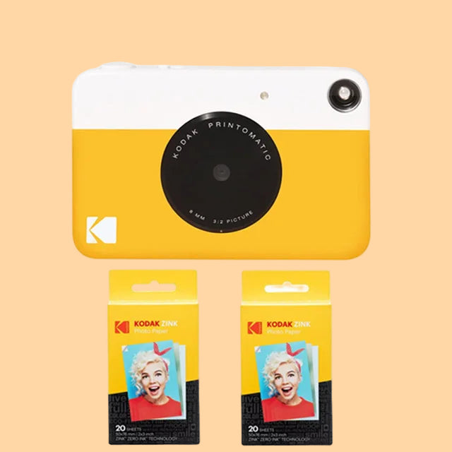 Kodak Printomatic camera and photo papers on a white background
