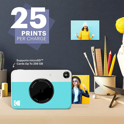 Kodak Printomatic camera with printed photos on a desk, promotional text about print capacity and microSD card support.