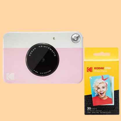 Pink Kodak Printomatic camera with a package of Kodak photo papers on a white background